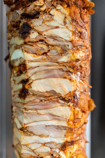 Türk sokak yemeği Doner Kebap için dikey şiş tavuk eti yakın çekim.