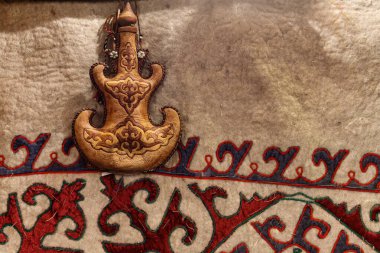 Torsyk - Orta Asya desenli bir halının arka planında Türk süsü bulunan içecekler için Kazak ulusal konteynırı.
