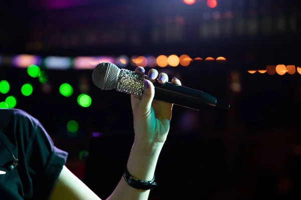 Draadloze microfoon met strass in vrouw hand op het nachtclub podium — Stockfoto