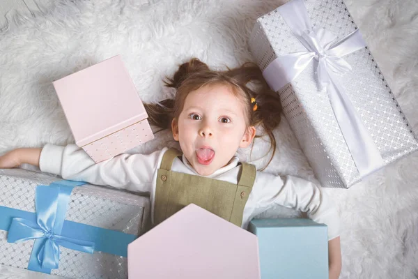 Mutlu kız dilini uzatır çünkü bir sürü yeni yıl hediyesi alır.