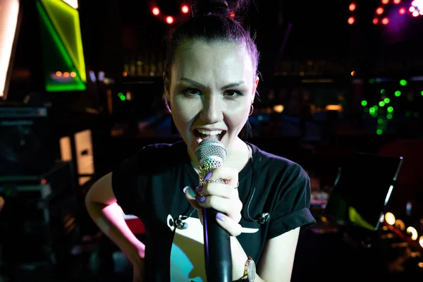 Young singing woman with a microphone live band vocalist Shake it band on the stage of a nightclub — Stock Photo, Image