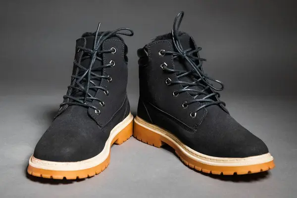 Pair of black winter mens boots on a gray background — Foto Stock