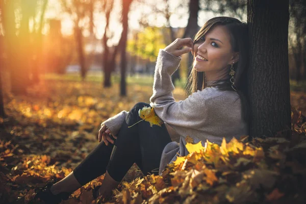 Sonbahar Parkında Gün Batımında Ağaçların Yanında Oturan Mutlu Melez Kadın — Stok fotoğraf