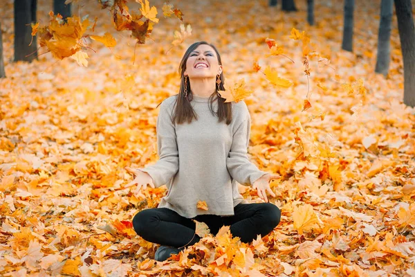 Lächelnde Junge Frau Die Herbstpark Auf Dem Laub Sitzt Und — Stockfoto