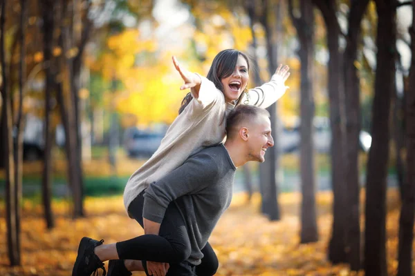 Happy Smiling Man Carrying His Laughing Girlfriend Back Autumn Nature — Fotografia de Stock