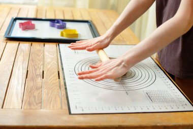 Woman using culinary silicone mat for cooking homemade baking.