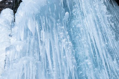Winter background of ice, icicles and ice stalactites.