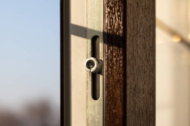 Close-up detail of the locking mechanism of a plastic window.