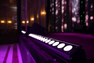 Profesyonel ışıklandırma ekipmanları etkinlik salonunda sahnede yatıyor..