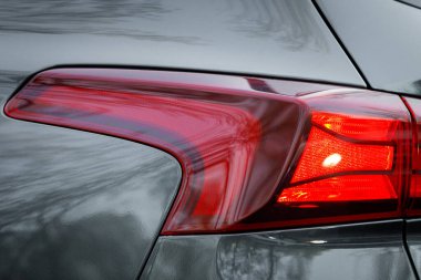 Gri bir arabanın arka lambasına yakın çekim..