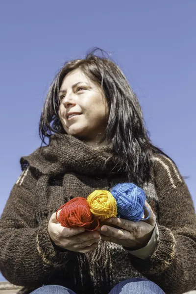 Young knitter with coloured yarns of wool