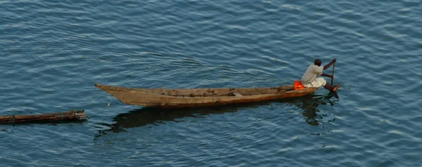 Rwandan Man Paddles Long Boat pulling Logs — Stock Photo, Image