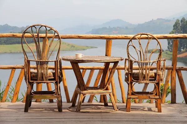 Wicker Deck Chairs with Coffee on a Table and a Lake View Stock Photo