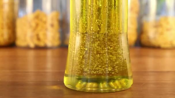 Goldene Blasen ändern im Olivenölglas die Richtung — Stockvideo