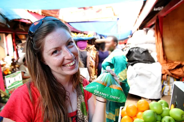 Giovane donna che compra mele nel mercato — Foto Stock