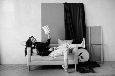 Güzel kıvırcık saçlı, deri ceketli esmer bir kız lüks saçlar için poz veriyor.