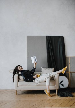 Güzel kıvırcık saçlı, deri ceketli esmer bir kız lüks saçlar için poz veriyor.