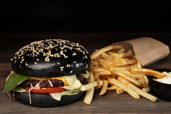 Burger noir sur tableau noir avec frites — Photo