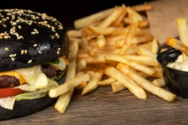Burger noir sur tableau noir avec frites — Photo