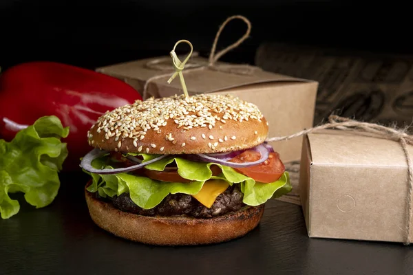 Burger na ciemnym tle z frytkami — Zdjęcie stockowe