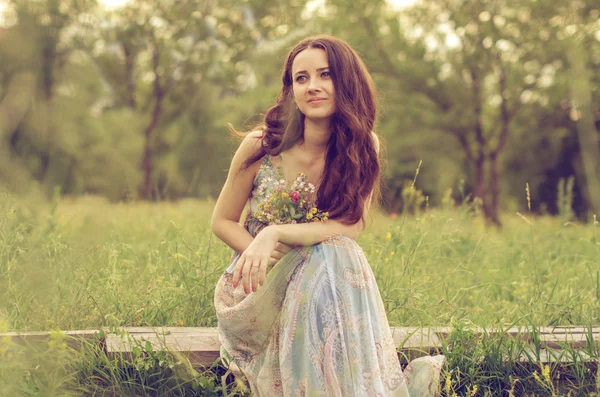Menina bonita sentada no prado — Fotografia de Stock