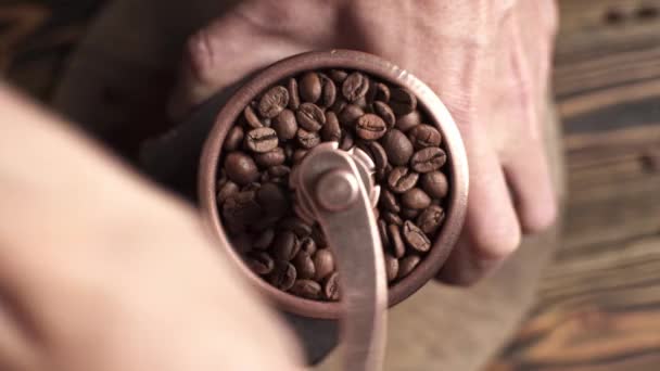 Macinazione di chicchi di caffè aromatici con macinino manuale. Rotazione regolare della fotocamera. Vista dall'alto — Video Stock