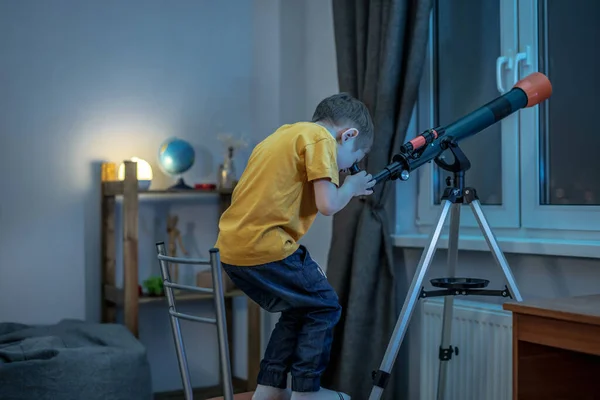 Χαριτωμένο Αγόρι Κοιτάζει Μέσα Από Ένα Τηλεσκόπιο Ένα Δωμάτιο Στο — Φωτογραφία Αρχείου