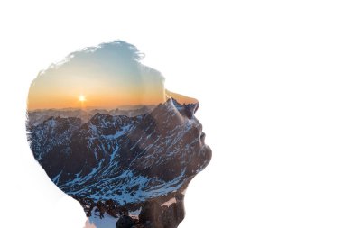 Bir adamın siluetinin izole bir kombinasyonu ve dağlarla kaplı bir manzara ve batan güneş. İnsan ve doğa arasındaki bağlantı kavramı