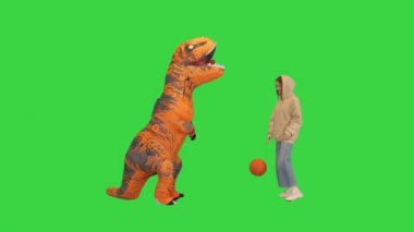 Yeşil Ekran 'da Dino kostümlü bir adamla basketbol oynayan kız, Chroma Key..