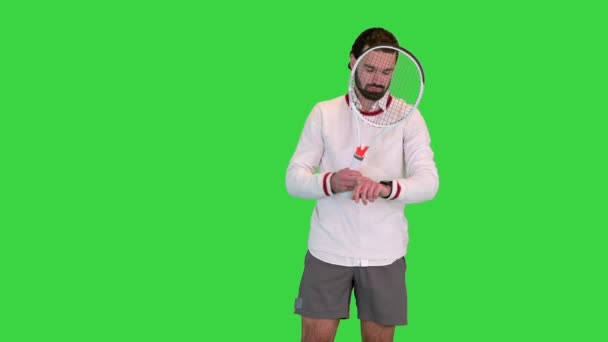 Jóképű férfi teniszező néz az okos óra egy zöld képernyőn, Chroma Key. — Stock videók