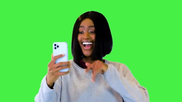Счастливая молодая черная женщина говорить на смартфоне с помощью видео подключение вызова приложения ходить и улыбаться на зеленом экране, Chroma Key. — стоковое видео