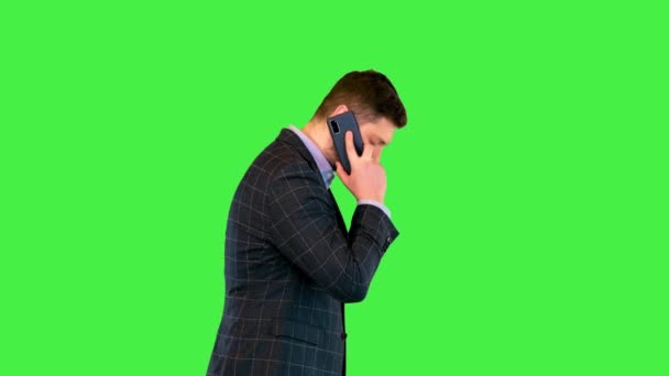 Biznesmen mówiący na smartfonie Zajęty millenium lider biznesu chodzić podczas rozmowy telefonicznej na zielonym ekranie, Chroma Key. — Wideo stockowe