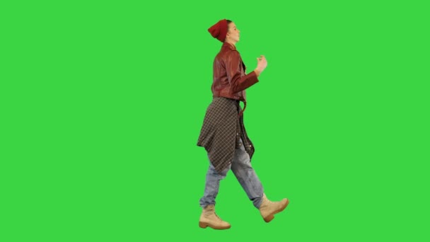 Młoda dziewczyna w stylowych miejskich ubrań spacery taniec lekko, pstrykając palcami na zielonym ekranie, Chroma Key. — Wideo stockowe