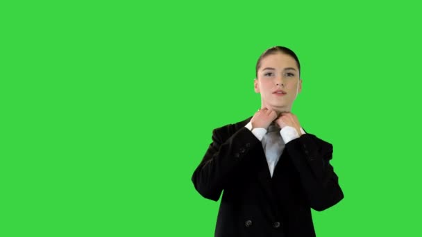 Νεαρή γυναίκα προσαρμόζει το κοστούμι του γραφείου της, σταυρώνει τα χέρια, βάζει χέρι στο ισχίο σε μια πράσινη οθόνη, Chroma Key. — Αρχείο Βίντεο
