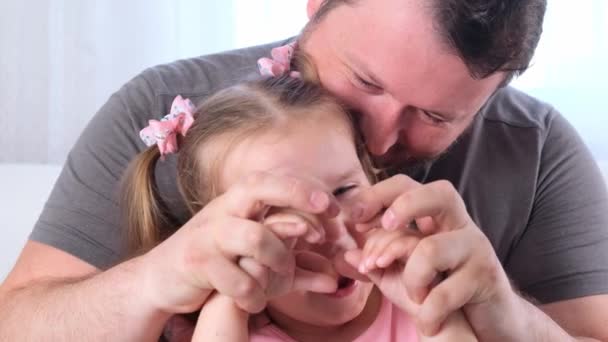 Divertida hija de 3 años y el padre se divierten en casa, hacer un corazón de las manos. divertirse con el niño, tiempo libre, trucos, concepto tonto. día del padre — Vídeo de stock