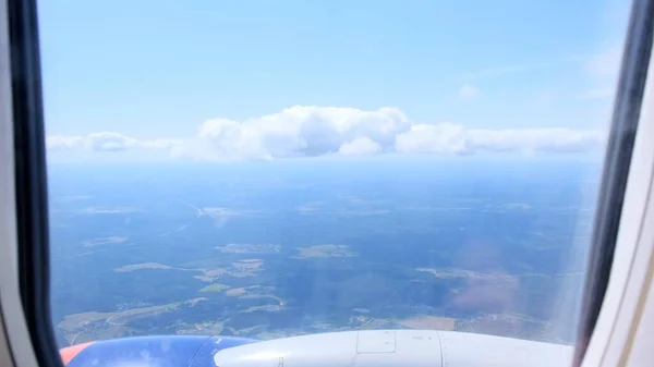 Nuages et ciel vus à travers la fenêtre d'un avion. Concept volant et voyageant, vue de la fenêtre de l'avion sur l'aile — Photo