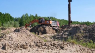 Sarı kazıcı, 30 Ağustos 2021 'de Moskova, Rusya' da bir inşaat sahasında kum kazarak toprak çalışmalarını gerçekleştirir..