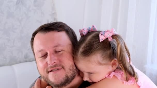 Retrato de papá e hija sonrientes, de 3 años, jugando en casa. Día de los Padres. Hombre joven guapo en casa con su pequeña linda chica se divierten juntos. Concepto de paternidad, infancia feliz — Vídeos de Stock