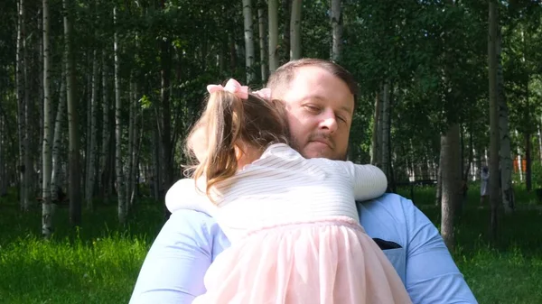 Strong Father holds on his arms a sweet daughter, 3 years old, hugs her and hugs her. The concept of parenting, overcoming problems in the relationship between father and daughter, illness, fear for — Stock Photo, Image