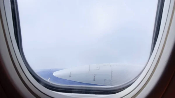 Nuvens e céu como visto através da janela de uma aeronave. Conceito voando e viajando, vista da janela do avião na asa — Fotografia de Stock