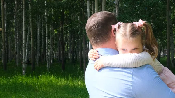 Padre forte tiene tra le braccia una dolce figlia, di 3 anni, la abbraccia e la abbraccia. Il concetto di genitorialità, superamento dei problemi nel rapporto tra padre e figlia, malattia, paura per — Foto Stock