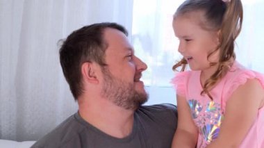 Üç yaşındaki tatlı küçük kızım ve babam evde nazikçe sarılıp eğleniyorlar. Bebeğinle iyi eğlenceler, aptal konsept. Babalar günü. ebeveynlik, çocuklar ve ebeveynler arasındaki ilişkiler