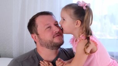 Üç yaşındaki tatlı küçük kızım ve babam evde nazikçe sarılıp eğleniyorlar. Bebeğinle iyi eğlenceler, aptal konsept. Babalar günü. ebeveynlik, çocuklar ve ebeveynler arasındaki ilişkiler