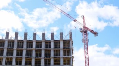 İkametgah inşaat endüstrisi. Bir apartman dairesinin inşasına eşit katılım. İpotek. Bina yapım aşamasında ve gökyüzünün arka planında bir vinç