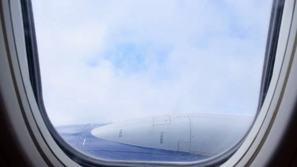 Wolken und Himmel aus dem Fenster eines Flugzeugs. Konzept Fliegen und Reisen, Blick aus dem Flugzeugfenster auf die Tragfläche — Stockfoto