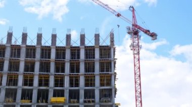 İkametgah inşaat endüstrisi. Bir apartman dairesinin inşasına eşit katılım. İpotek. Bina yapım aşamasında ve gökyüzünün arka planında bir vinç