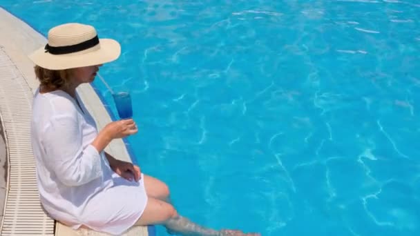 Старшая женщина отдыхает в бассейне отеля. Люди наслаждаются летними каникулами. Все включено — стоковое видео