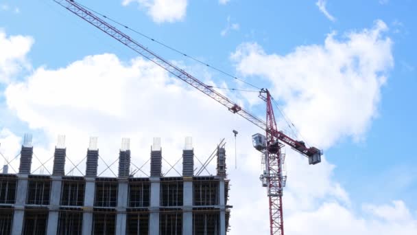 Construction industry. High rise building under construction and construction crane up to the sky. Housing construction, apartment building in the city, mortgage — Stock Video