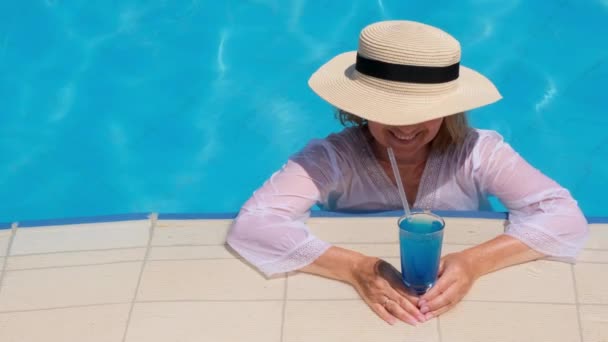 Seniorin entspannt sich im Hotelschwimmbecken. Die Menschen genießen ihren Sommerurlaub. All inclusive — Stockvideo