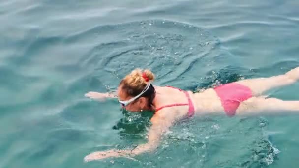 Vrouw 50-55-60 jaar oud, draagt een bril, traint om in zee te kruipen. Professionele zwemmer, zwemwedstrijd. Voorste kruipende zwemmer. Zwemlessen. — Stockvideo